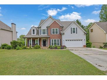 Charming two-story home with brick accents and a well-manicured lawn at 1663 Willow Way, Woodstock, GA 30188