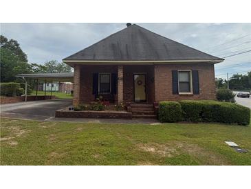 Charming brick home featuring a covered carport and a well-maintained front lawn and flower beds at 871 Malcom Se St, Conyers, GA 30012