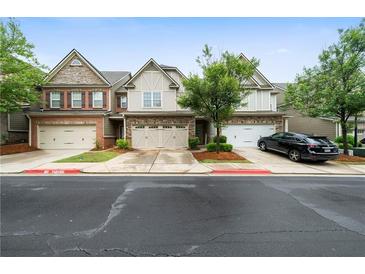 Charming townhomes featuring stone accents, manicured lawns, and attached garages at 1630 Marsanne Nw Ter # 27, Kennesaw, GA 30152