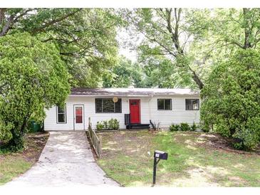 Charming single-story home featuring a bright red front door and a neatly maintained front lawn at 5904 Heatherwood Ln, Riverdale, GA 30296