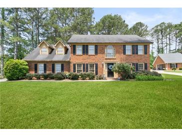 Traditional brick home with manicured lawn and mature trees in a well-maintained community at 3472 Honeycomb Se Dr, Conyers, GA 30094