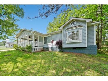 Charming single-story home boasts a inviting front porch and manicured lawn at 3428 Quail Sw Run, Marietta, GA 30008