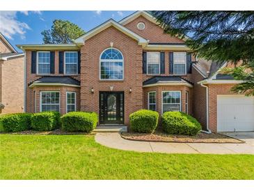 Traditional two-story brick home featuring a manicured lawn and a classic front door design at 1013 Odelle Cir, Mcdonough, GA 30253