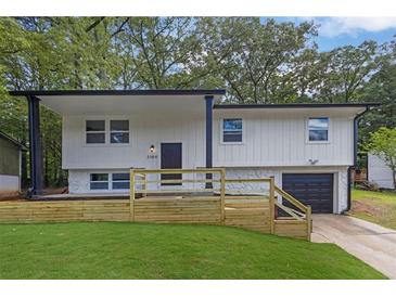 Charming exterior elevation view of a home with modern design elements and a well-maintained lawn at 2184 Cherokee Valley Cir, Lithonia, GA 30058