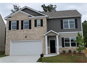 Charming two-story home with a brick facade, complemented by black shutters and a well-manicured front lawn at 3650 River Rock Rd, Lithonia, GA 30038