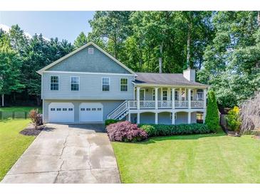 Charming two-story home featuring a covered front porch and a two-car garage at 850 Old Spring Way, Sugar Hill, GA 30518