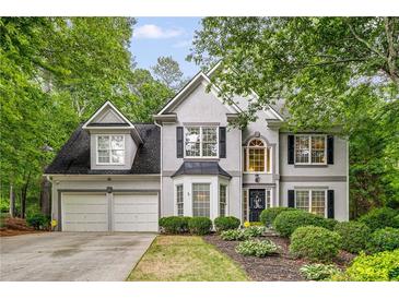 Charming two-story home with a well-manicured lawn, two-car garage and inviting front entrance framed by lush greenery at 3953 Lorien Nw Way, Kennesaw, GA 30152