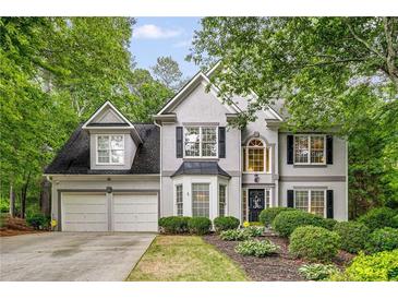 Charming two-story home featuring a two-car garage, landscaped yard, and a classic design with black shutters and gray siding at 3953 Lorien Nw Way, Kennesaw, GA 30152