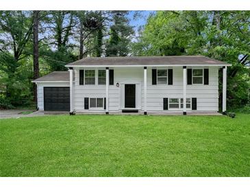 Charming two-story home featuring a well-maintained lawn and attached garage at 1386 Pineglen Dr, Riverdale, GA 30296