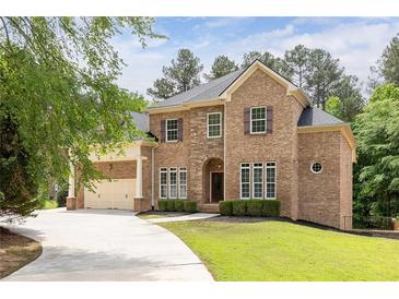 Beautiful brick home featuring manicured landscaping, a three-car garage, and a welcoming front entrance at 3512 Centerville Rosebud Rd, Snellville, GA 30039