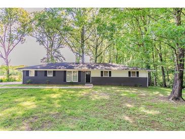 Charming home with a dark brick facade, contrasting white siding, and a lush green lawn at 545 Fayetteville Rd, Fairburn, GA 30213