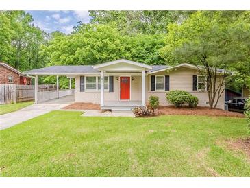 Charming ranch home with a well-manicured lawn, bright red door, and covered parking at 733 San Fernando Se Dr, Smyrna, GA 30080