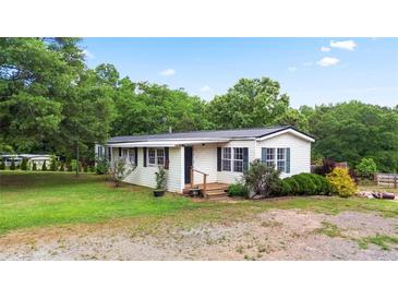 Charming single-story home with green lawn, lush landscaping, and classic black shutters at 901 N Van Wert Rd, Villa Rica, GA 30180
