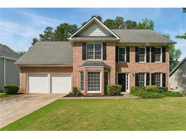 Charming two-story brick home with a well-manicured lawn and a two-car garage at 3570 Steve Nw Dr, Marietta, GA 30064