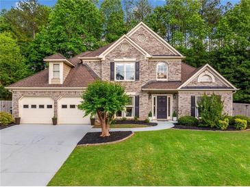Two-story brick home with a three-car garage and manicured lawn at 3707 Lance Bluff Ln, Duluth, GA 30097