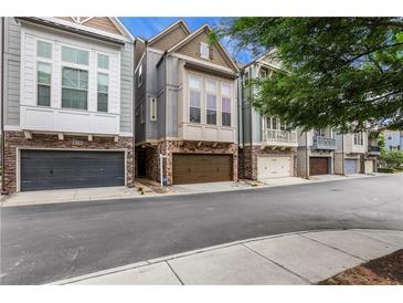 Charming townhomes featuring stone accents, gray siding, and attached two-car garages at 3005 Devoncroft Se St, Smyrna, GA 30080