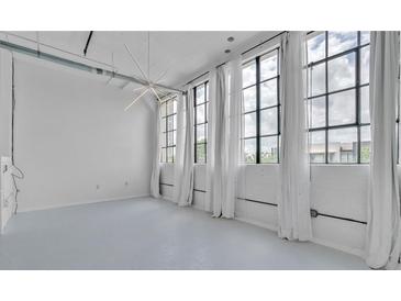 Bright, airy living room with large windows, white walls, and modern lighting for a serene, loft-like atmosphere at 881 Memorial Se Dr # 307, Atlanta, GA 30316