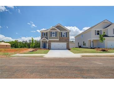 Inviting two-story home featuring brick accents, a two-car garage, and professionally landscaped front yard at 17 Camellia Dr, Fairburn, GA 30213