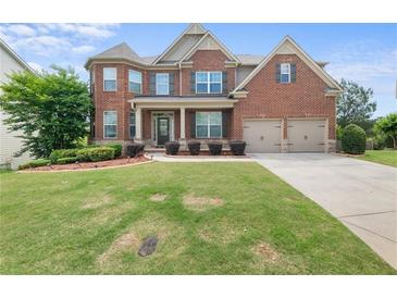 Charming two-story brick home with a well-manicured lawn and a two-car garage at 4060 Brumby Ln, Cumming, GA 30041