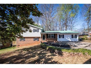 Charming two-story home with brick accents and a green metal roof, set on a landscaped lot at 6225 Pebble Dr, Douglasville, GA 30135