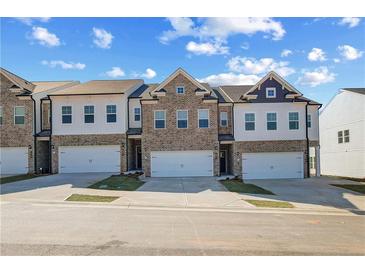 New townhomes feature brick and siding exteriors, attached garages, and landscaping at 907 Eagle Ave, Riverdale, GA 30296