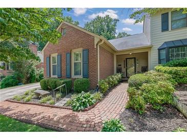 Charming brick home featuring a landscaped yard and inviting front porch with a stone bench at 1236 Whitlock Ridge Sw Dr, Marietta, GA 30064