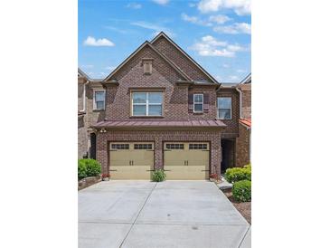 Charming two-story brick townhome with a two-car garage and well-maintained landscaping at 1929 Brightleaf Way, Marietta, GA 30060