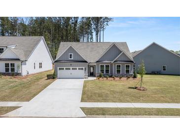 Charming single-story home with a gray exterior, well-manicured lawn, and a spacious two-car garage at 22 Foothills Trl, Sharpsburg, GA 30277
