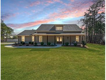 Charming single-story home with a well-manicured lawn and inviting covered front porch at 8007 Wishaw Ct, Winston, GA 30187