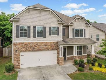 Charming two-story home featuring stone accents, a two-car garage, and a welcoming front porch at 3805 Alden Pl, Cumming, GA 30028
