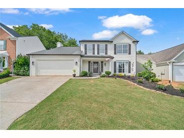 Charming two-story home with a well-manicured lawn, black shutters and a two car garage at 565 Barsham Way, Johns Creek, GA 30097