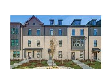Charming townhome featuring classic architectural details and a professionally landscaped front yard at 525 Rubato Knl, Mcdonough, GA 30253
