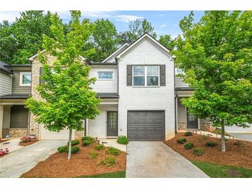 Charming townhome with a painted brick facade, well-manicured landscaping, and a one-car garage at 3181 Meadowstone Sw Ln, Atlanta, GA 30331