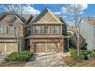 Inviting two-story brick townhome with a two-car garage and a well-manicured lawn at 5711 Keys Way, Lithonia, GA 30058