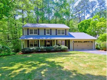 Charming two-story home with a well-manicured lawn, mature trees, and attached two car garage at 351 Ridgewater Dr, Marietta, GA 30068
