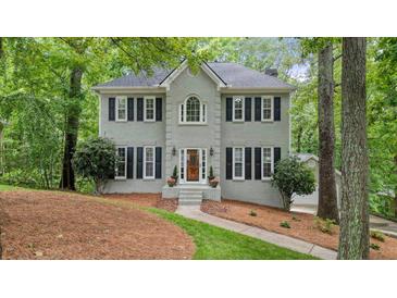 Charming gray two-story home featuring black shutters, a landscaped yard, and mature trees at 3267 Standing Peachtree Nw Trl, Kennesaw, GA 30152