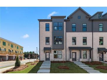Modern townhome exterior with brick facade, gray accents, and well-maintained landscaping at 533 Rubato Knl, Mcdonough, GA 30253