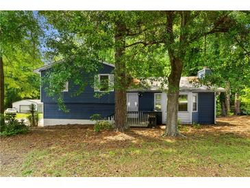 Charming blue house exterior with a well-maintained lawn and mature trees in a peaceful setting at 35 Pawn Dr, Carrollton, GA 30116