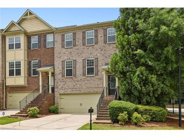 Brick townhome featuring attached garages, well maintained landscaping, and a welcoming entrance at 3694 Lambert Ne Ln, Atlanta, GA 30319