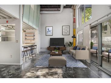 Bright living room with high ceilings, modern furnishings, and sliding glass doors to the outside at 195 Arizona Ave # 179, Atlanta, GA 30307