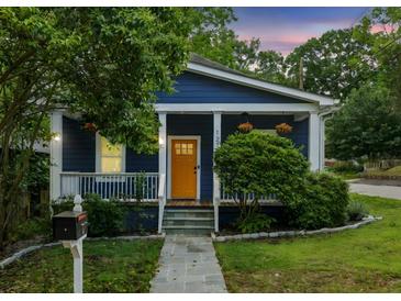 Charming blue bungalow with a welcoming yellow front door and well-manicured landscaping at 1211 Mortimer Se Pl, Atlanta, GA 30317