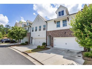 Charming townhome exterior showcasing a blend of brick and siding, complemented by well-manicured landscaping at 408 Niles Ct, Marietta, GA 30060