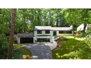 Charming two-story home with landscaped yard and dark trim surrounded by mature trees at 2858 Mornington Nw Dr, Atlanta, GA 30327