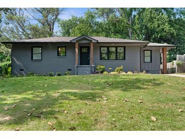 Charming brick home with manicured lawn and stylish wood porch columns at 1643 Flintwood Se Dr, Atlanta, GA 30316