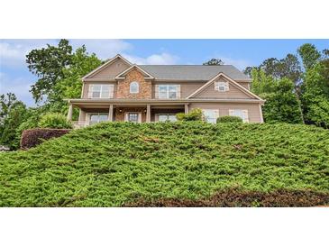 Charming two-story home features a stone facade, covered porch, and lush landscaping at 6086 Willowpond Ct, Douglasville, GA 30135