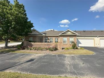 Charming single-story brick townhome with attached garage and meticulously manicured landscaping at 125 Villa Park Cir, Stone Mountain, GA 30087