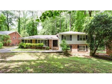 Charming home with brick and white siding, mature trees, and landscaped front yard offers great curb appeal at 2620 Clairmont Rd, Atlanta, GA 30329