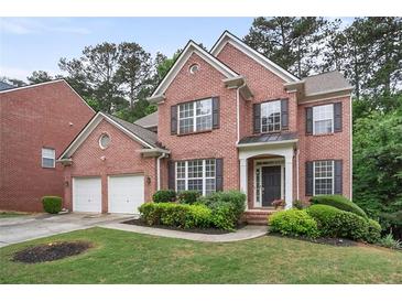 Charming two-story brick home featuring a well-manicured lawn and a two-car garage at 3962 Coventry Park Ln, Peachtree Corners, GA 30096