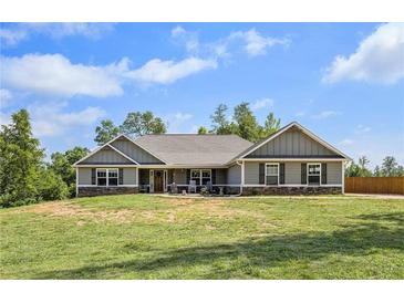 Charming single-story home with a well-maintained lawn and inviting front porch on a sunny day at 569 Lovell Rd, Temple, GA 30179