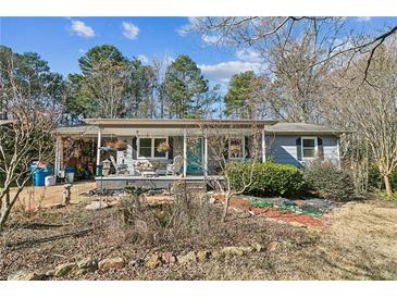 Charming single-story home featuring a cozy front porch with chairs and well-maintained landscaping at 315 Charlotte Blvd, Stockbridge, GA 30281